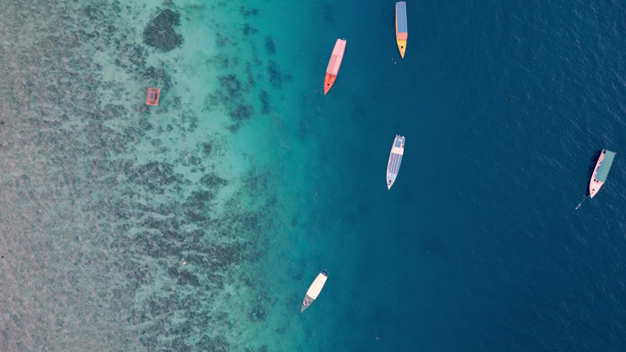 从空中俯瞰漂浮在蓝色水面上的船，夏日海岸的海景。海岸带自然中人游船休闲活动研究在大西洋海岸的海洋泻湖放松天气视频素材