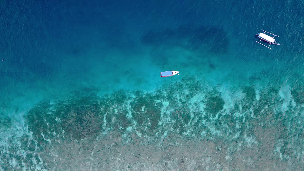 从空中俯瞰漂浮在蓝色水面上的船，夏日海岸的海景。海岸带自然中人游船休闲活动研究在大西洋海岸的海洋泻湖放松天气视频素材