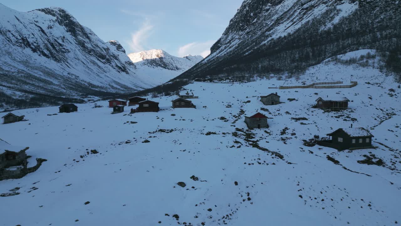 冬季，偏远的村庄坐落在白雪覆盖的山上，鸟瞰图视频素材