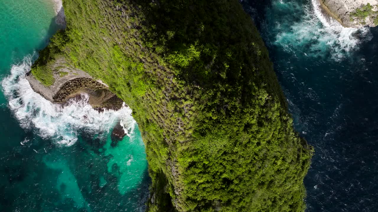 阳光明媚的夏日，印度尼西亚巴厘岛努沙佩尼达岛的科林金海滩上的绿色岬角。-航拍视频素材