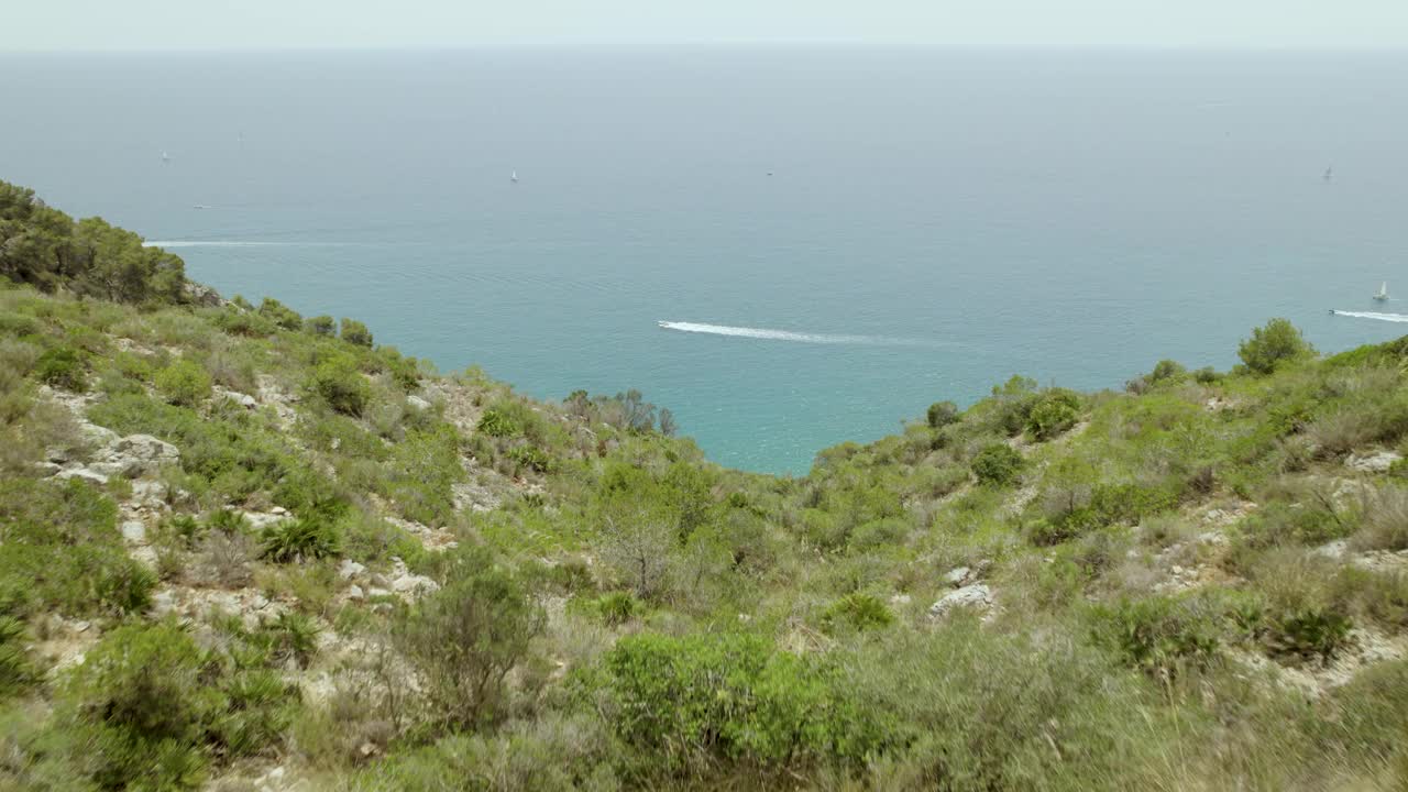 4k鸟瞰图，山脉和道路沿着海岸线的交通。海上的小船视频下载