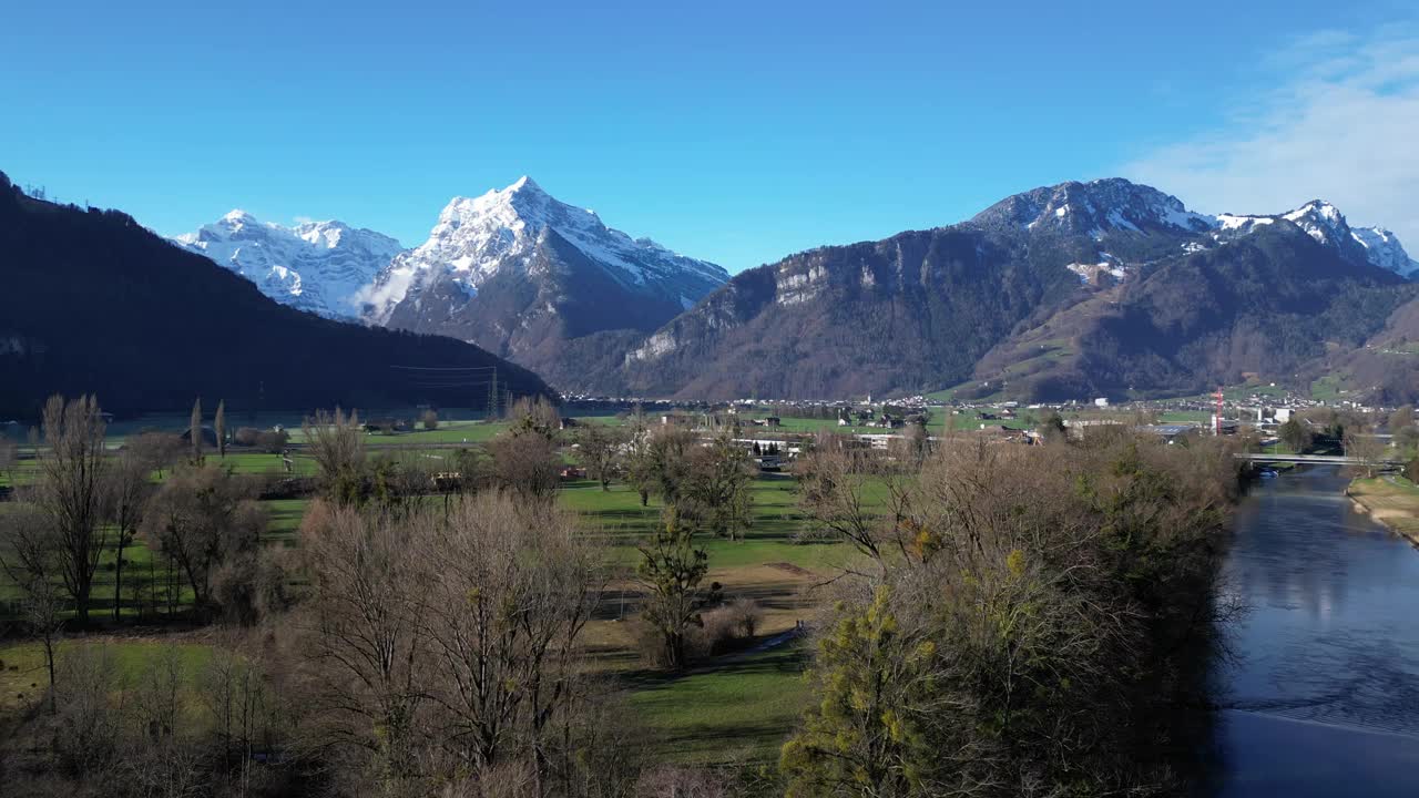 无人机剪辑显示阿尔卑斯山风景如画的雪山和草地低地视频素材