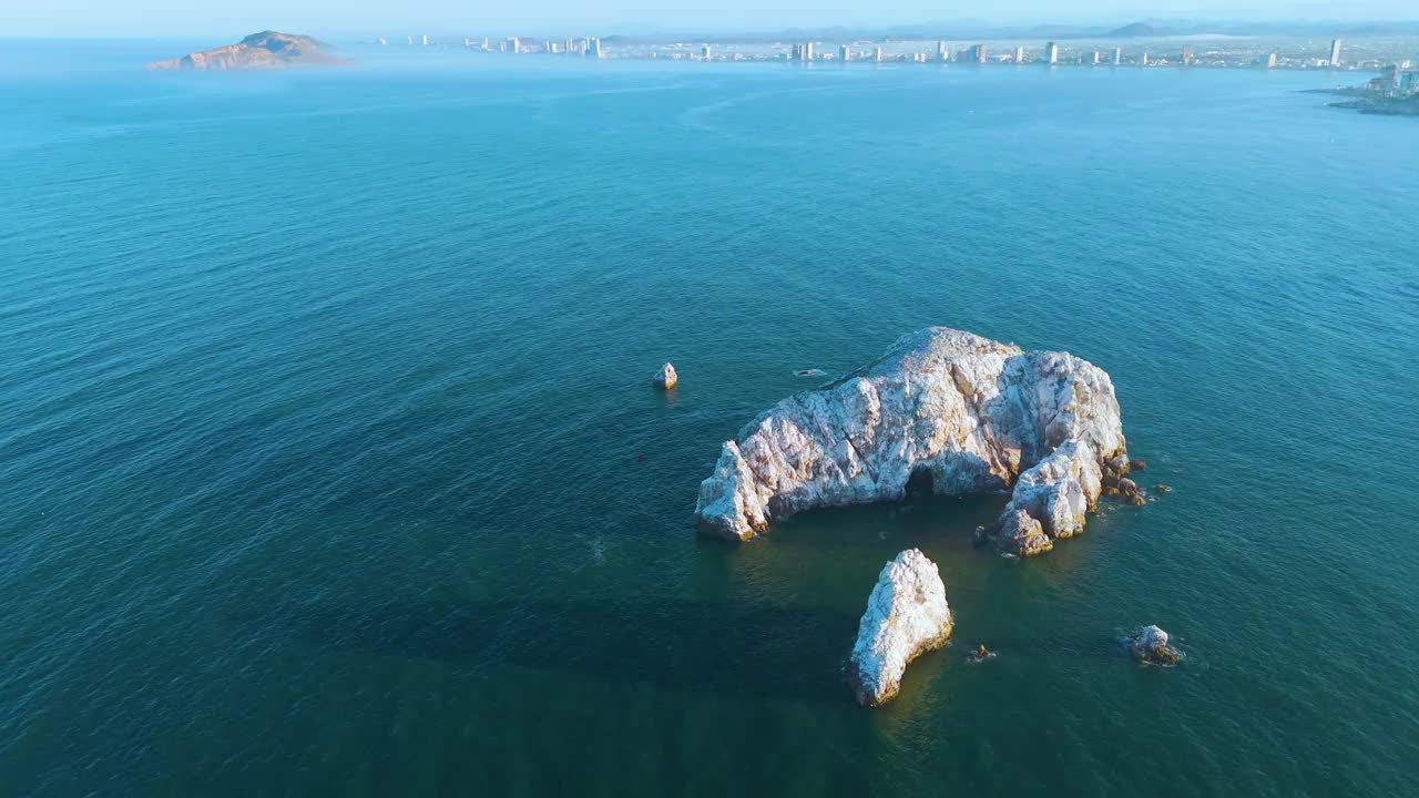 从高空拍摄的轨道照片揭示了一群漂浮在海洋中的原始小岛，就在墨西哥马萨特兰海岸附近。这张鸟瞰图展示了大海的浩瀚，勾勒出了目的地的自然魅力。视频素材