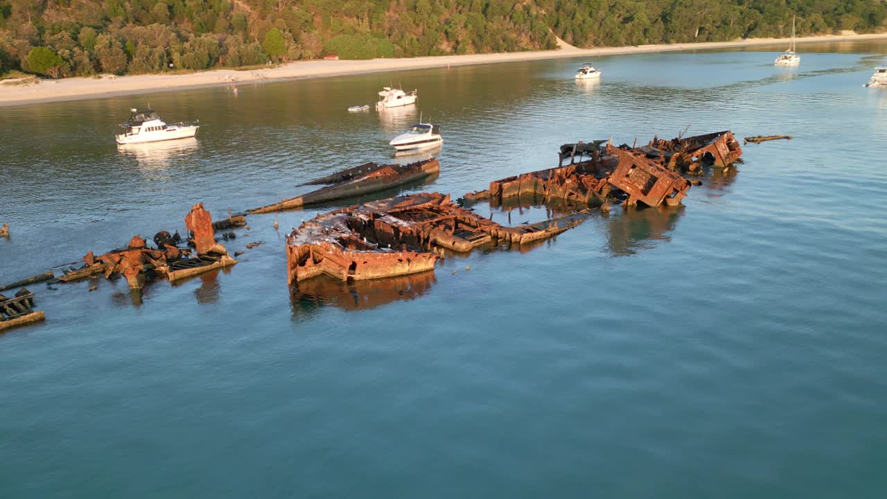 全景景观白沙海滩岛与沉没的船只，生锈的车辆在蓝色的海空中无人机，在摩顿岛的日光视图视频素材