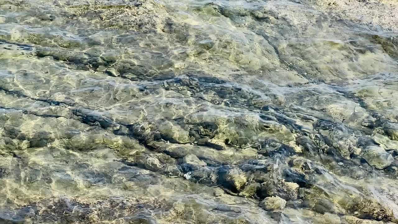 温和的海浪冲刷着鹅卵石沙滩，夏日旅行视频下载