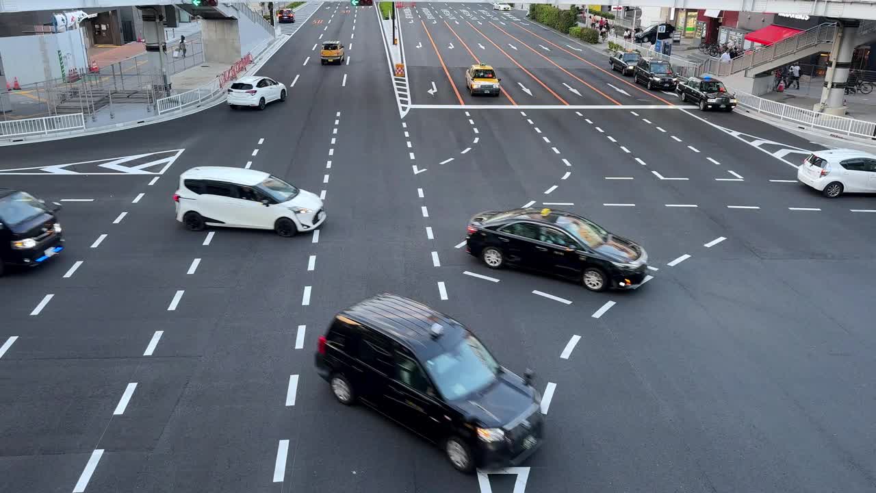 一个熙熙攘攘的城市十字路口，有各种各样的车辆和清晰的道路标志，日光，鸟瞰图视频素材