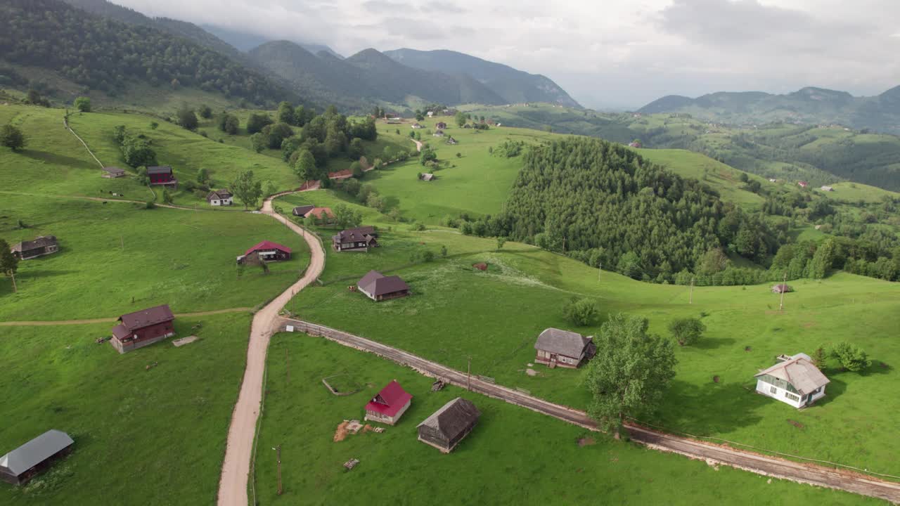 一个宁静的山村，蜿蜒的道路和郁郁葱葱的绿色植物，拍摄于白天，鸟瞰图视频素材