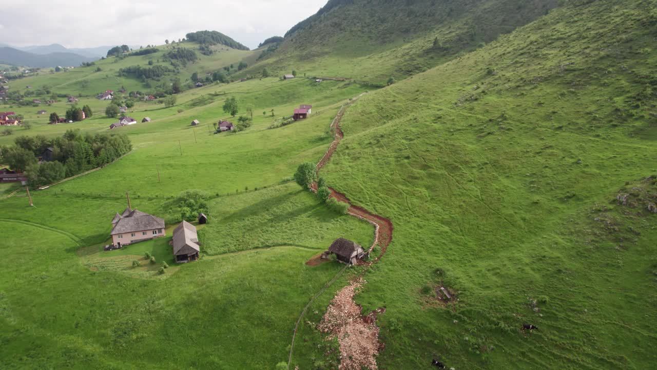 一个宁静的乡村，一条蜿蜒的道路在绿色的山丘之间，鸟瞰图视频素材