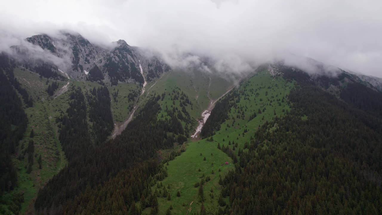 空中拍摄的云吻皮亚特拉克雷乌鲁山与郁郁葱葱的绿色斜坡视频素材