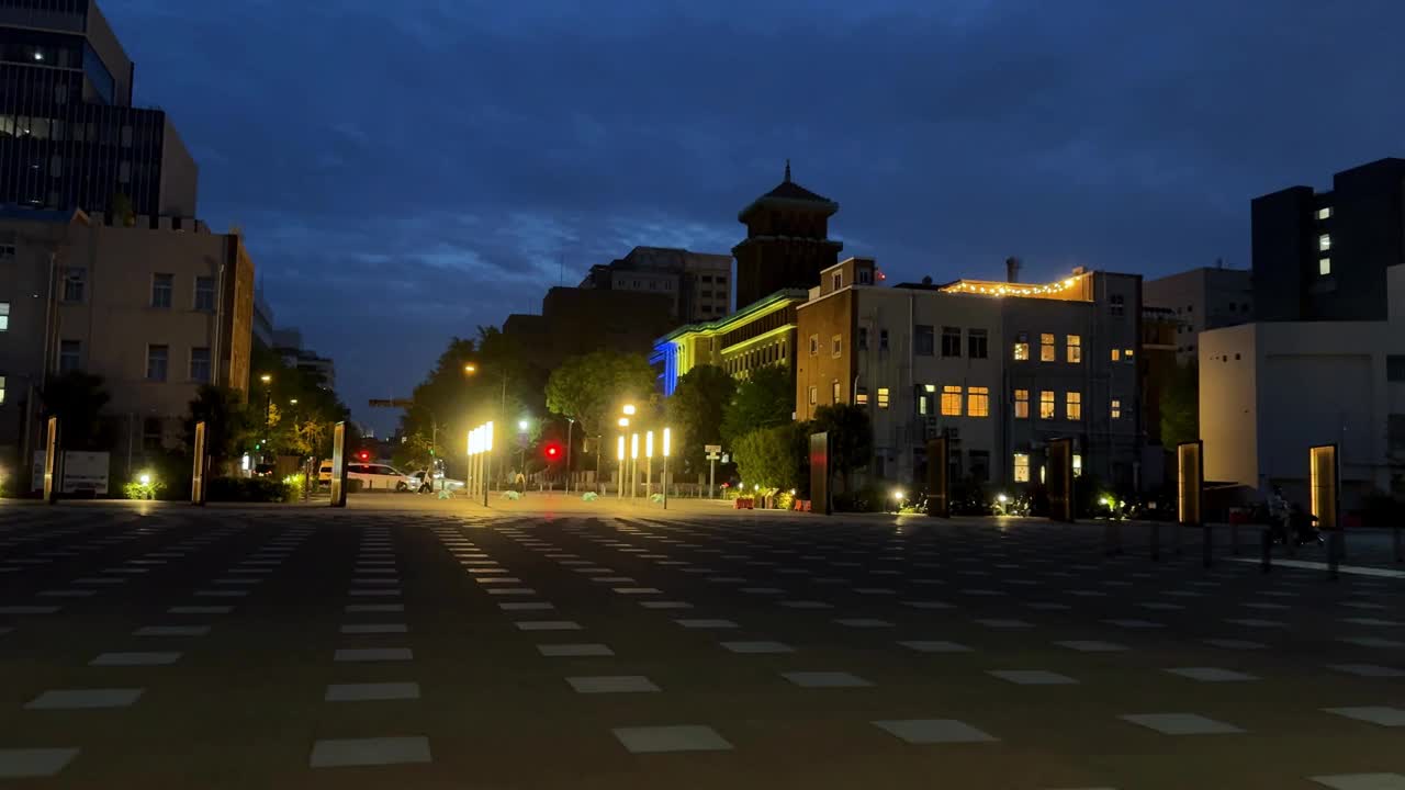 城市街道的黄昏城市景观，有照明的建筑物和交通灯视频素材