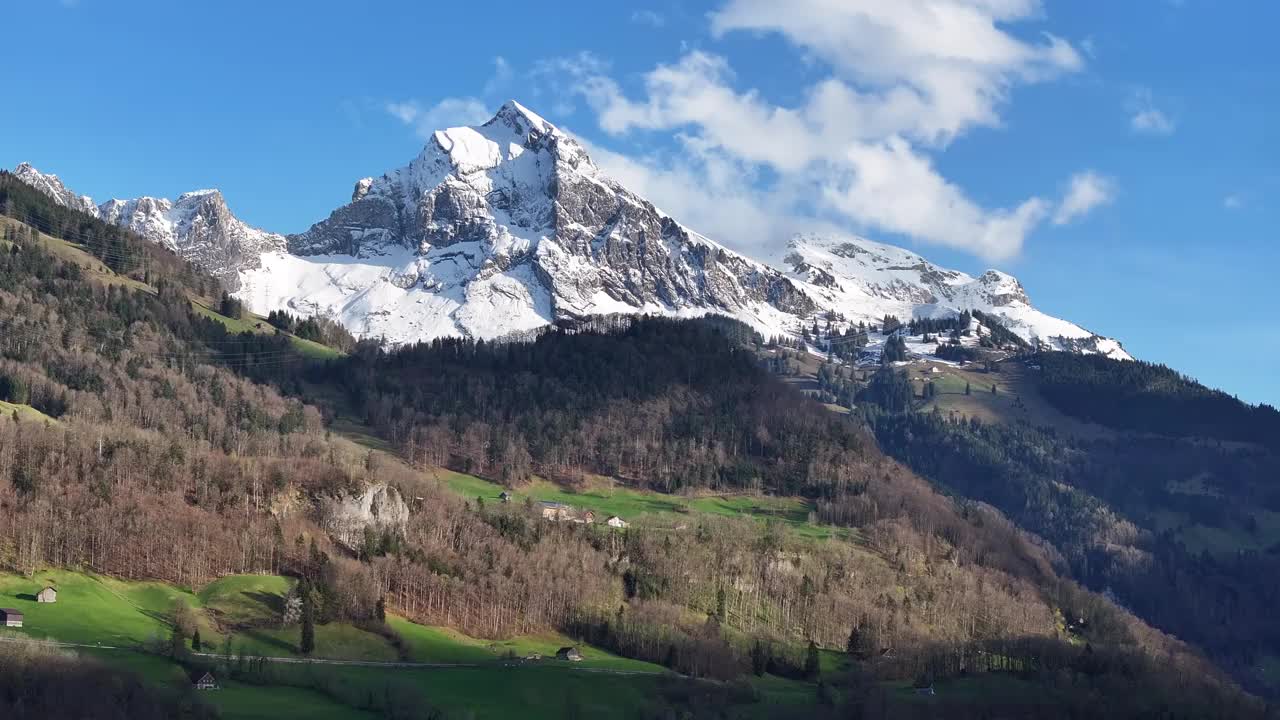 瑞士格拉鲁斯北部风景如画的白雪覆盖的山峰的航拍图，在没有雪的低海拔地区与森林接壤，山区高海拔和低海拔的概念。视频素材