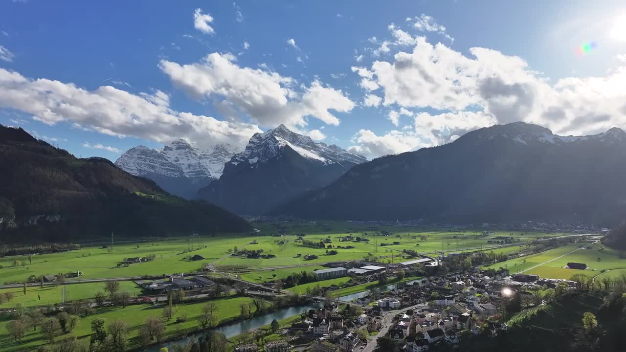 空中的格拉鲁斯北部风景如画的山谷，瑞士，揭示了一个田园诗般的场景，一个小定居点坐落在雪山，宁静的高山生活在大自然的宏伟。视频素材