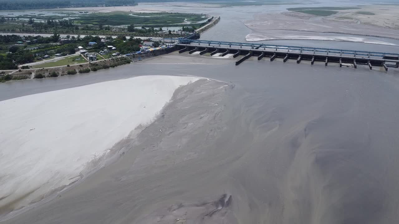 在印度一个阳光明媚的日子里，无人机拍摄的河流拦河坝视频素材