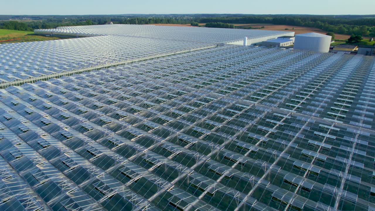 现代温室鸟瞰图。农业温室有机蔬菜栽培，农业工业。大型工业技术温室，透明玻璃屋顶，蔬菜。视频素材