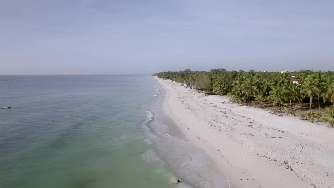 鸟瞰宁静的海滩，棕榈树和碧绿的海水，迪亚尼，肯尼亚。视频素材