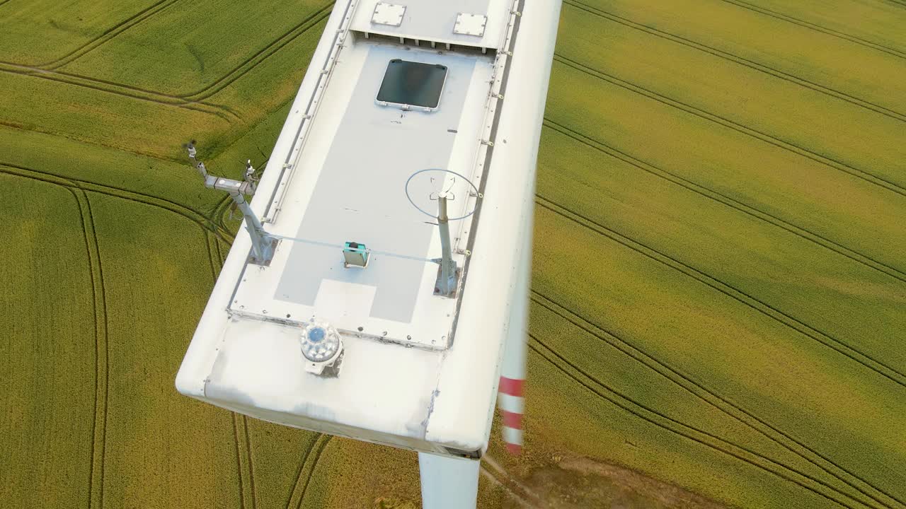 近距离风力涡轮机在现场。鸟瞰图旋转叶片产生清洁电力视频素材