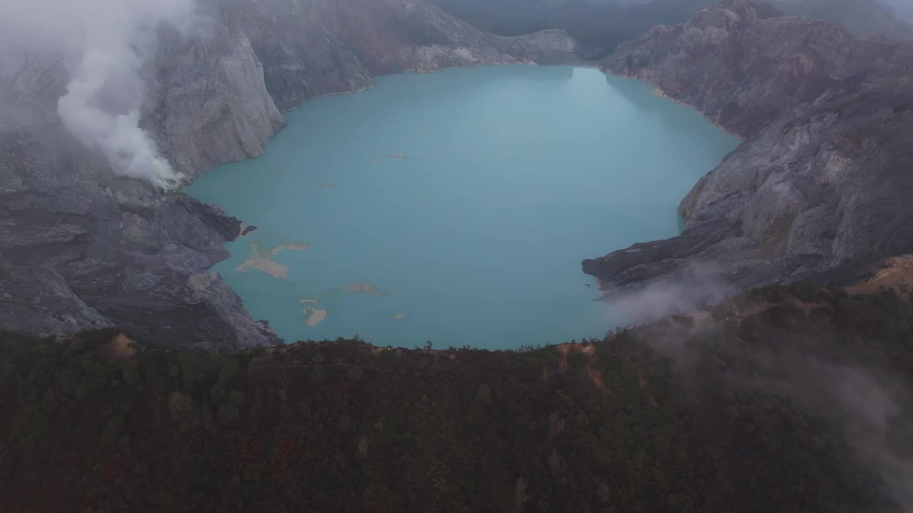 鸟瞰雾蒙蒙的伊真湖和冒烟的火山，爪哇，印度尼西亚。视频素材