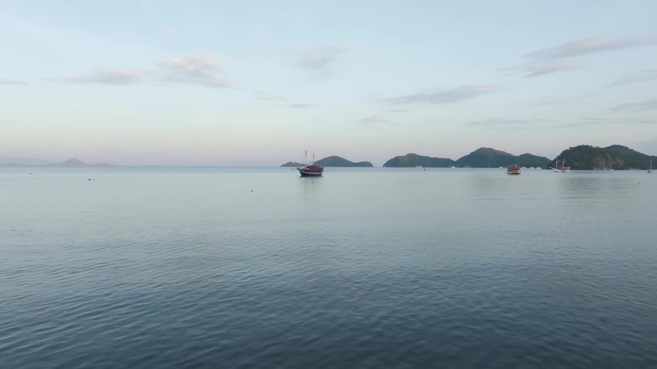 航拍的岛屿与帆船在宁静的大海，纳闽巴霍，印度尼西亚。视频素材