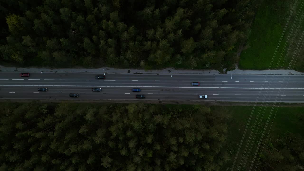 从空中拍摄的汽车行驶在森林公路上的夜晚，提供了一个从上面看风景视频素材