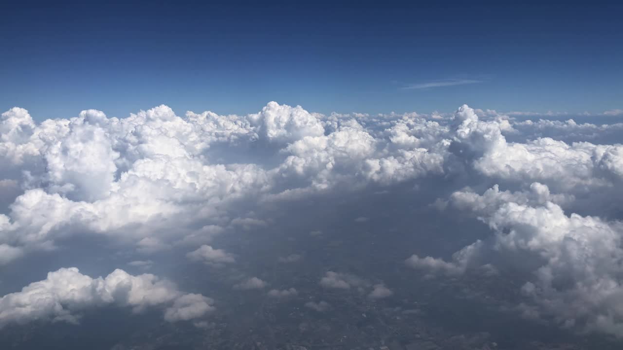 从空中鸟瞰蓬松的白色积云，背景是湛蓝的天空视频素材