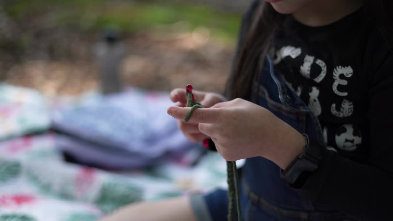 慢动作视频，一个小女孩戴着针织毛衣的眼镜，在森林的空地上视频下载