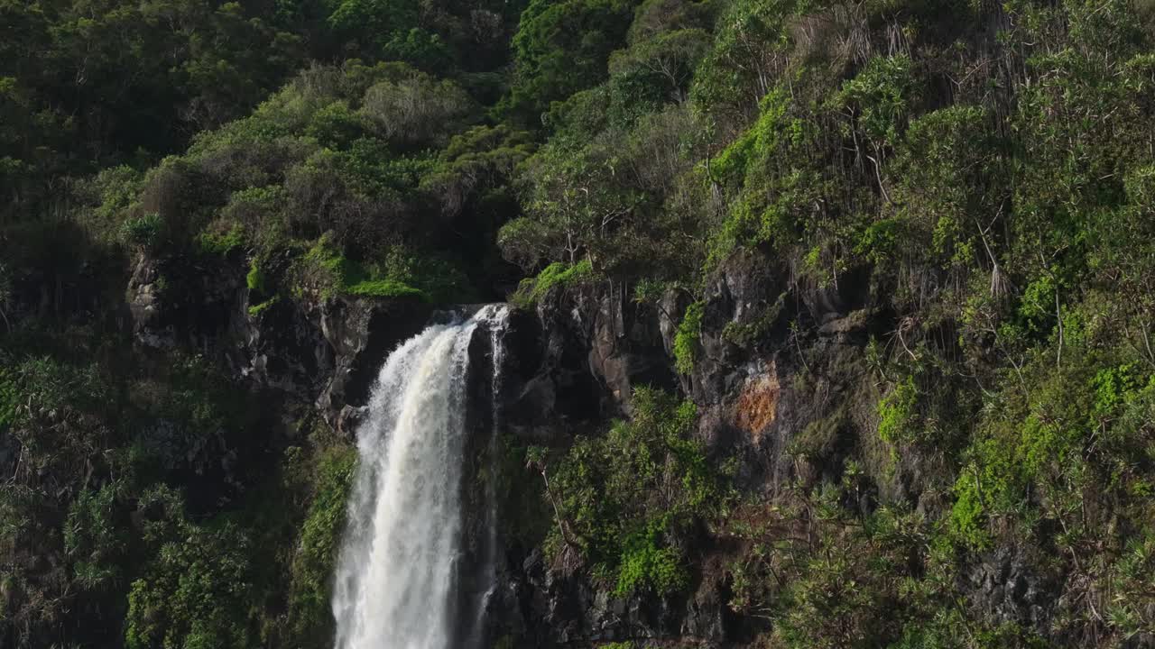 风景秀丽的瀑布在毛伊岛北岸的丛林悬崖边缘，无人机减速视频素材