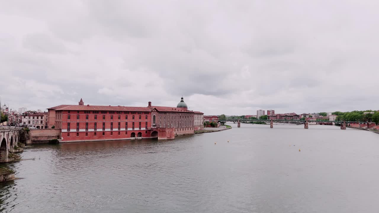 法国图卢兹有圆顶和桥的历史砖建筑的宁静河滨景观。视频素材