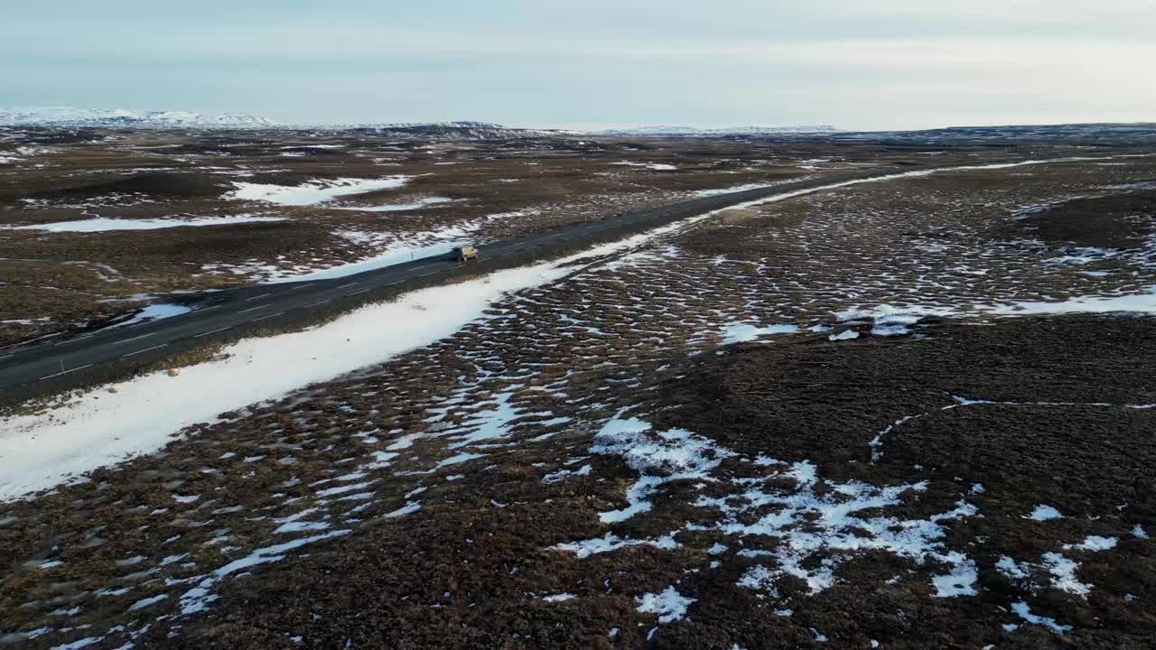 无人机拍摄的冰岛公路上的汽车在冬天下雪视频素材