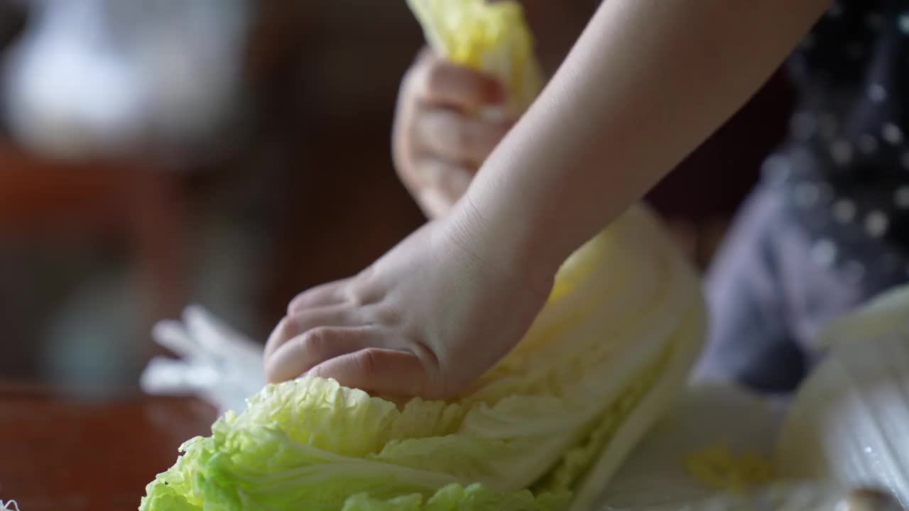 儿子帮妈妈撕菜做饭。视频素材