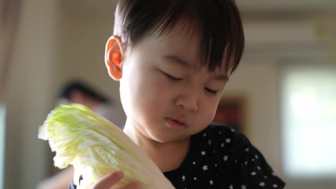 儿子帮妈妈撕菜做饭。视频下载