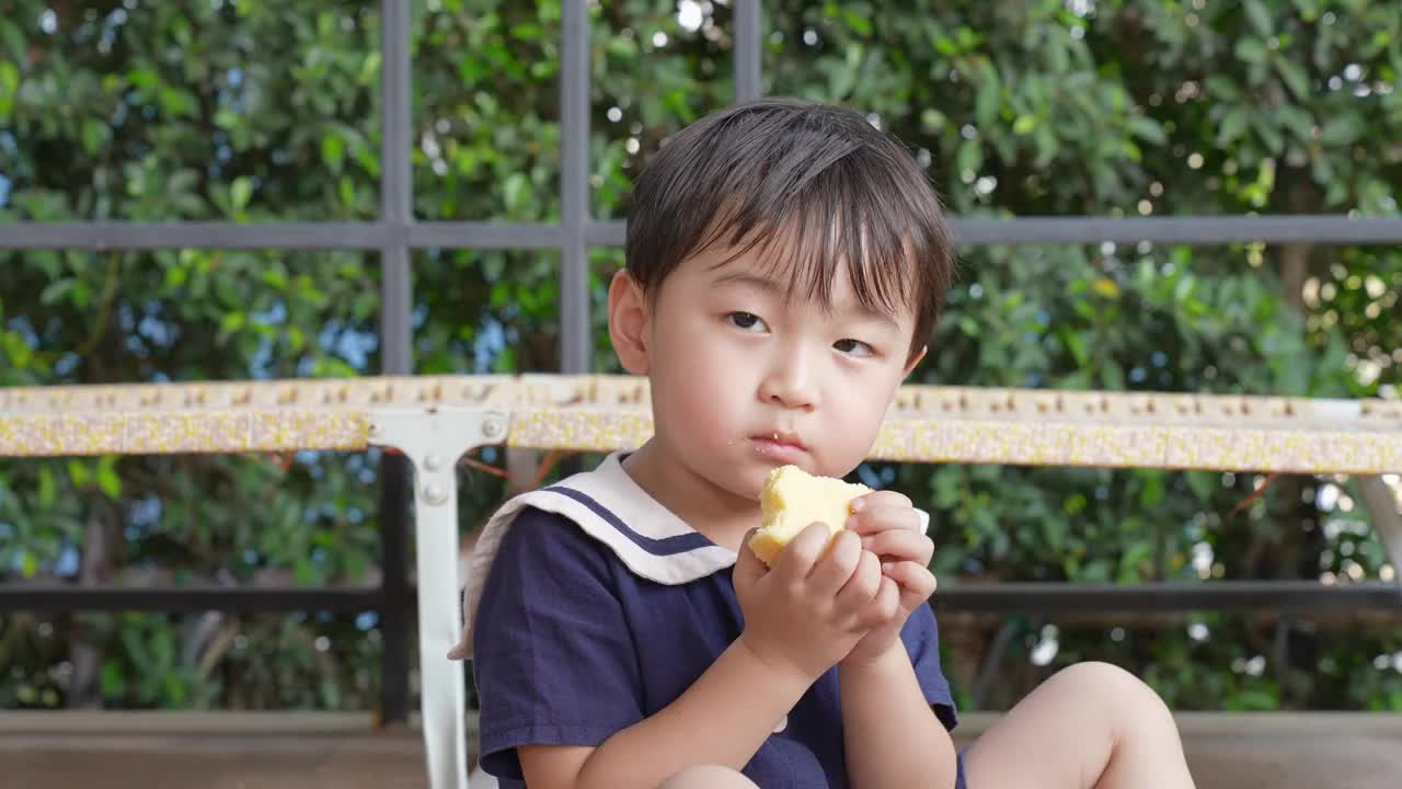 一个男孩和他的妈妈在阳台上愉快地吃午饭。视频素材