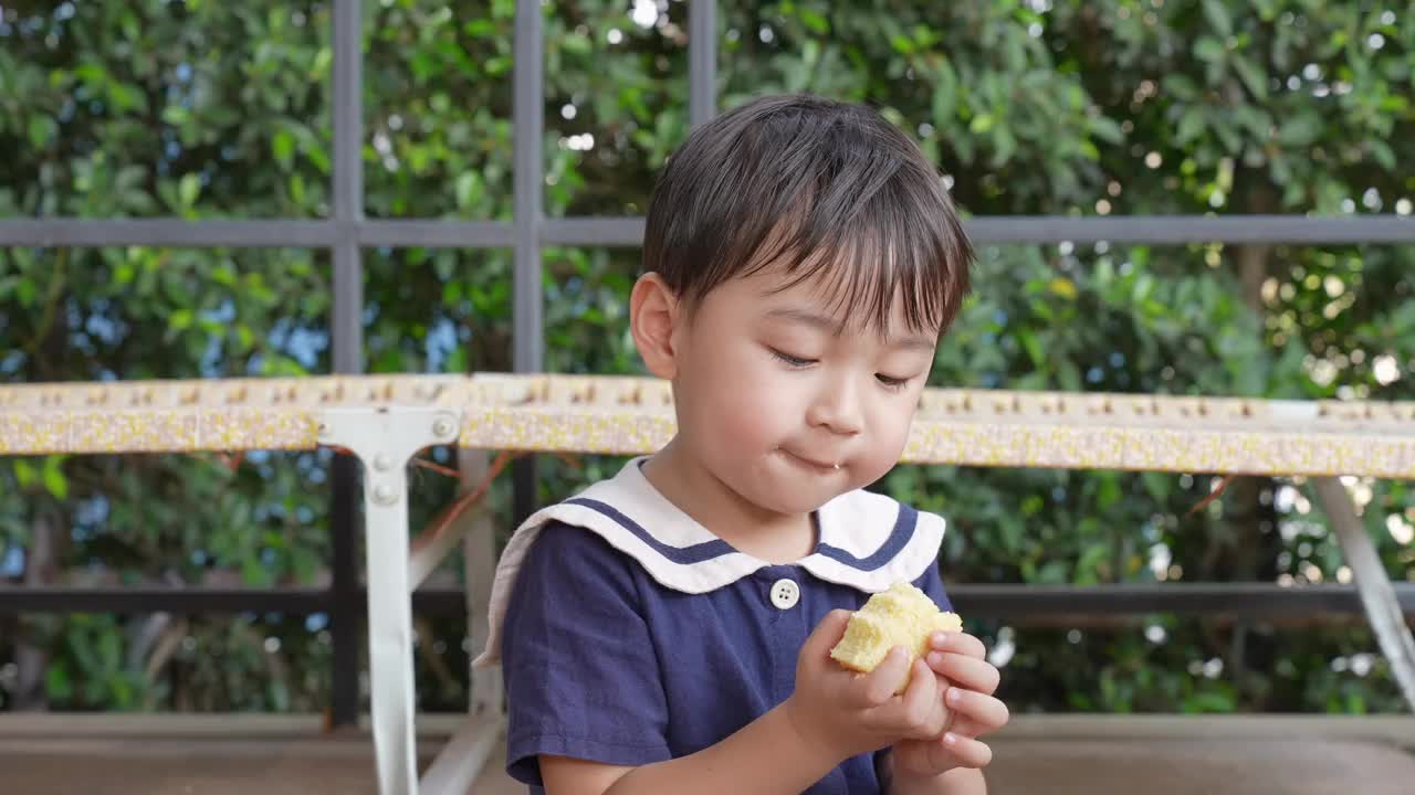 一个男孩和他的妈妈在阳台上愉快地吃午饭。视频下载