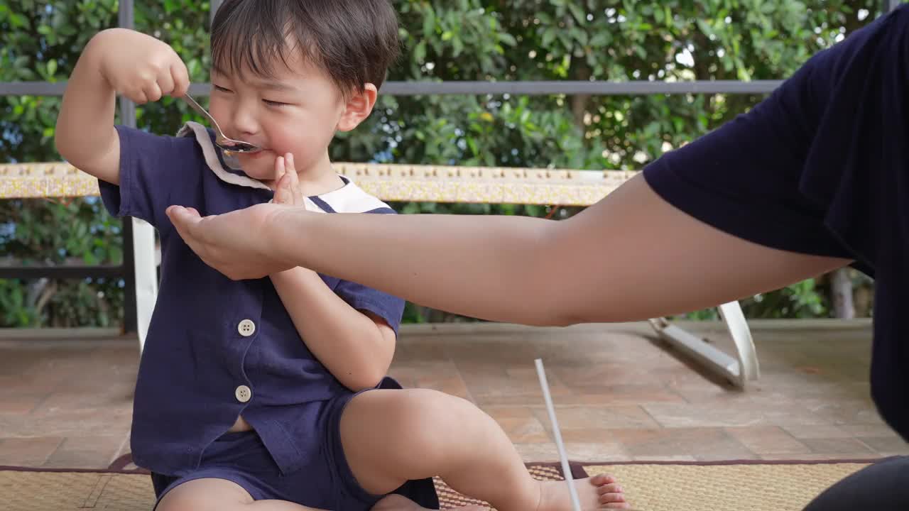 一个男孩和他的妈妈在阳台上愉快地吃午饭。视频下载