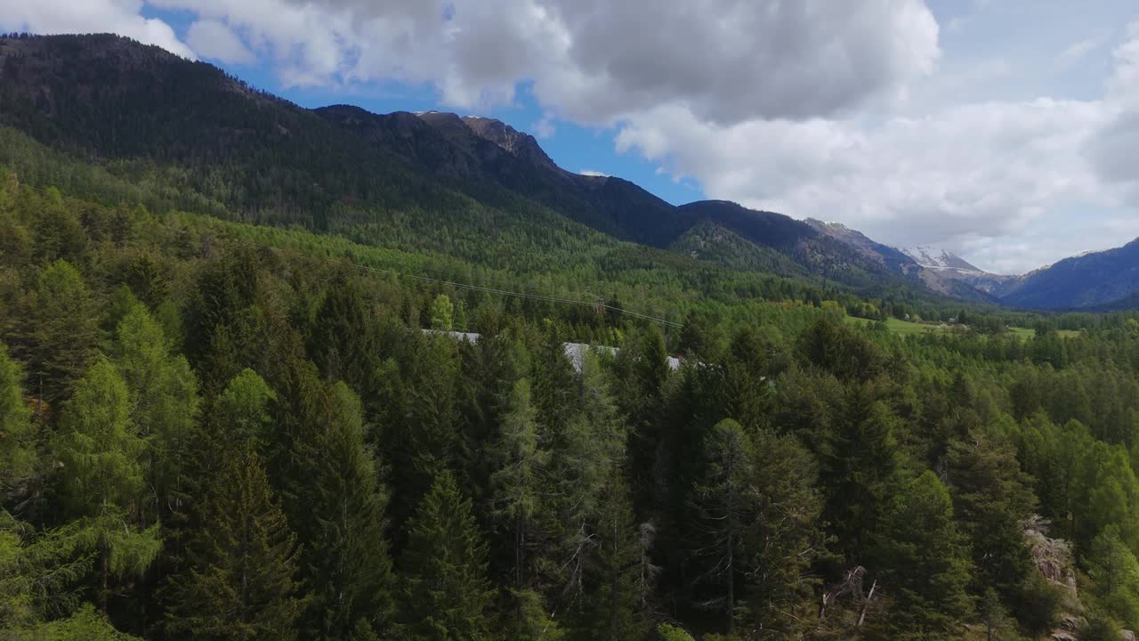 多云的天空下，郁郁葱葱的山间森林视频素材