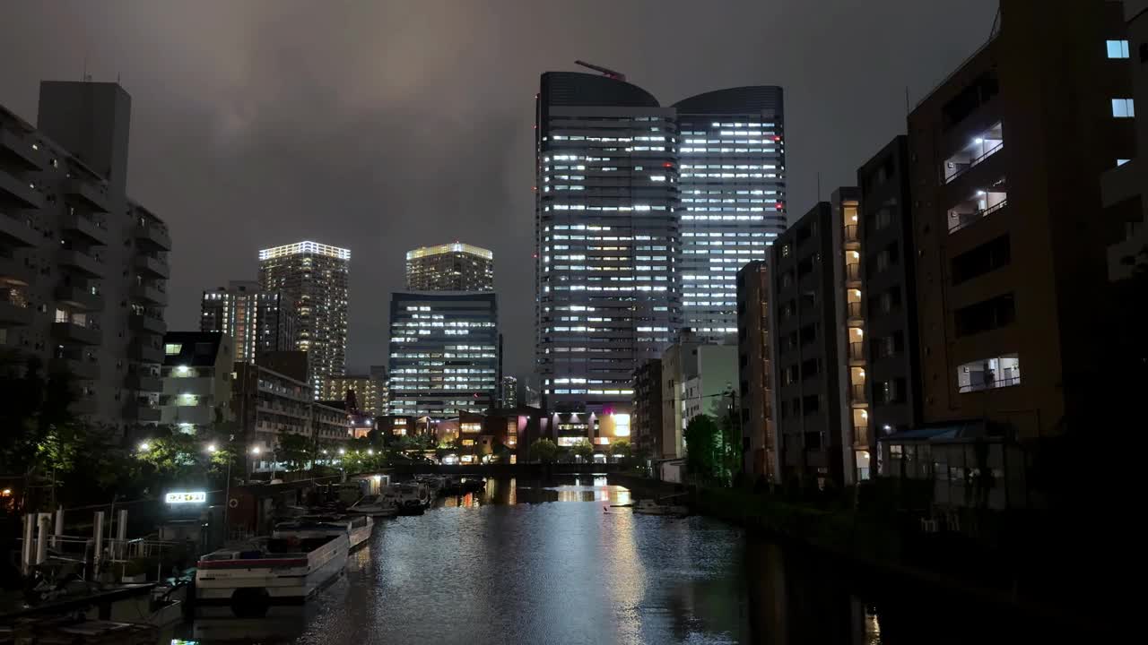 夜晚的城市天际线映照在河流上，营造出宁静的城市氛围视频素材