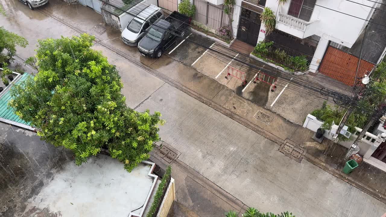 从高楼上拍摄的雨滴落在地上的画面。视频下载