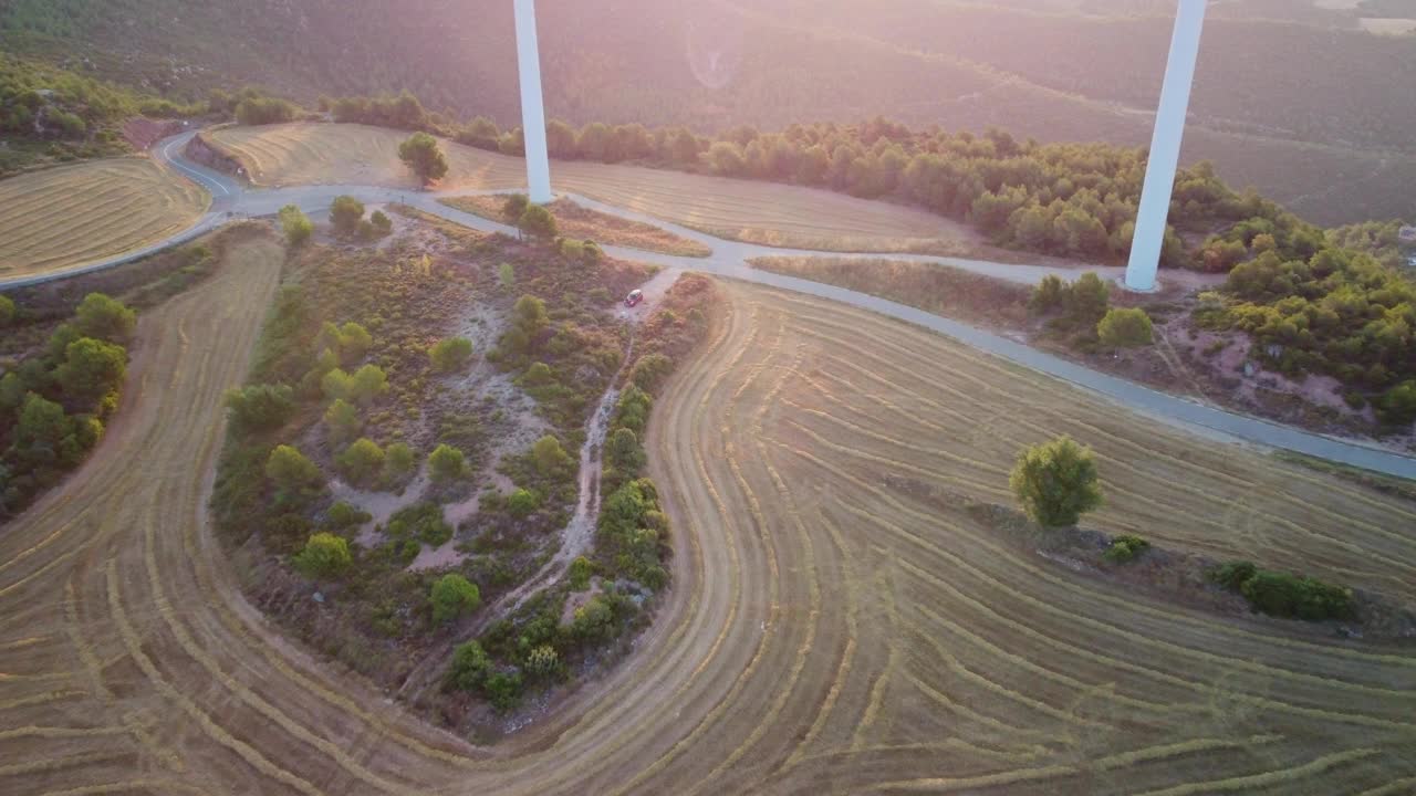 在伊瓜拉达的风车，巴塞罗那在日落投下长长的影子在起伏的山丘和道路视频素材