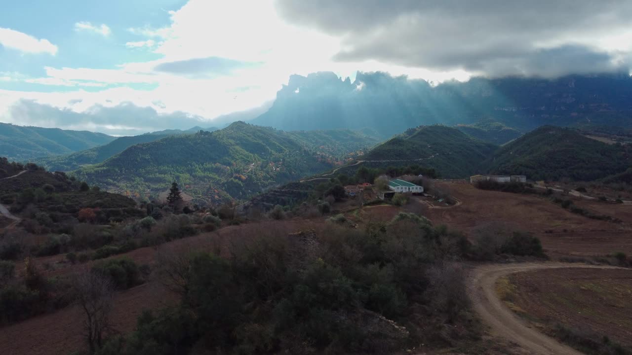 蒙特塞拉特和马加内尔的山景，散落的建筑物和穿过云层的阳光视频素材