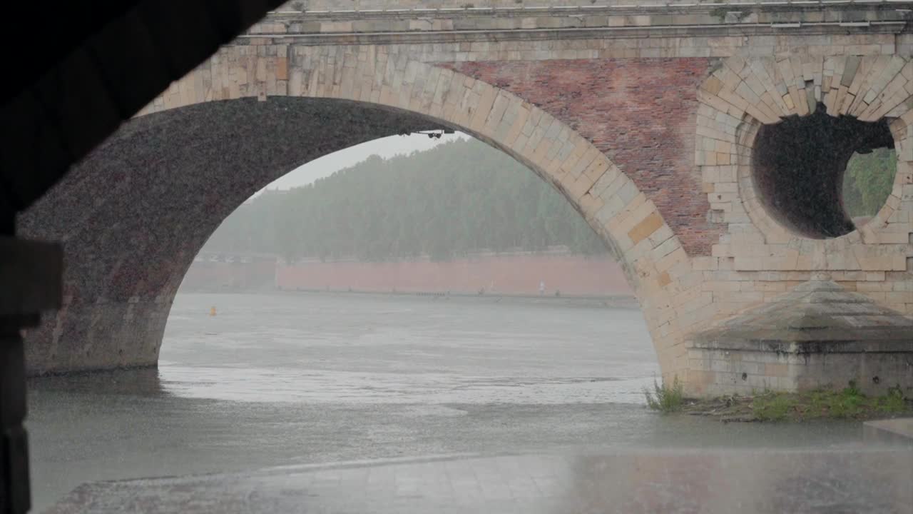 下雨天，在法国图卢兹的新桥下，河流在流动。视频素材