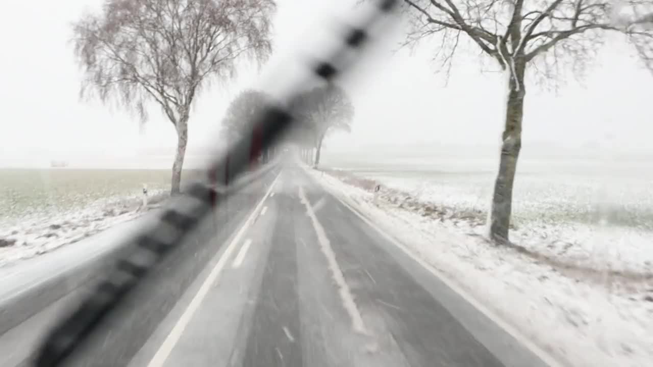 欣赏令人惊叹的冬季景色，在白雪覆盖的乡村道路两旁是贫瘠的树木视频素材