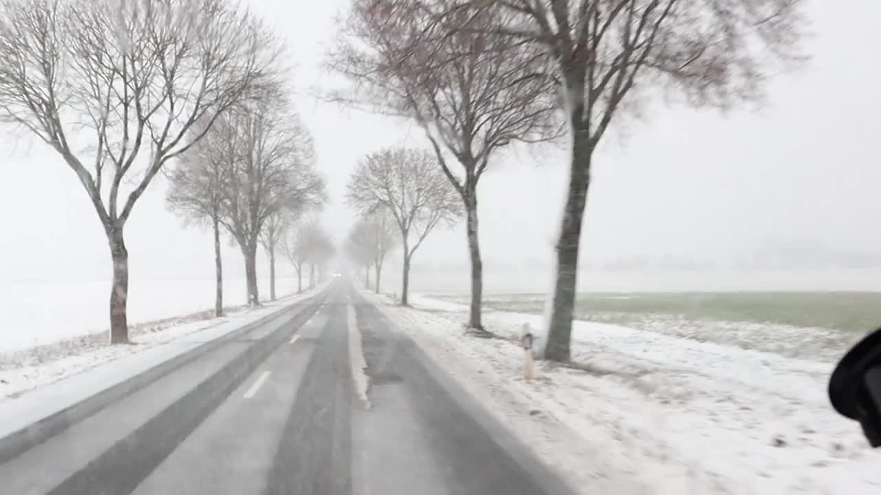 白雪覆盖的道路和树木在宁静的乡村景色中营造出宁静的氛围视频下载