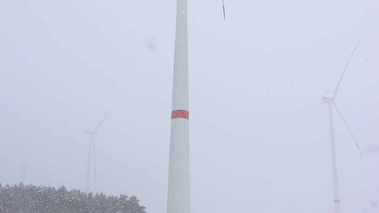 风力涡轮机在下雪的冬季运行良好，有效地利用了可再生能源视频素材