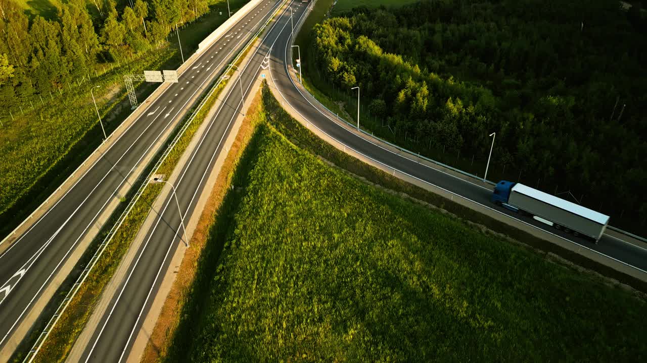 实时鸟瞰图一辆卡车在一个宁静的绿色景观的高速公路上，被自然和风景的美丽包围视频素材