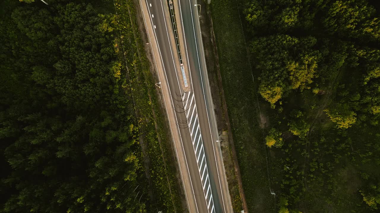 用无人机记录航拍镜头，展示公路和森林上现代交通和风景自然的融合视频素材