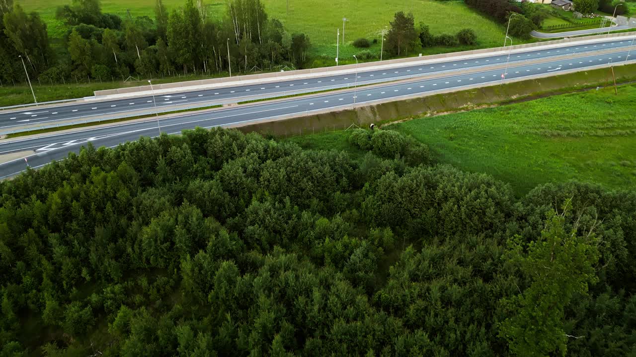 鸟瞰图显示了一条郁郁葱葱的乡村道路，一辆卡车经过，周围环绕着大自然和美丽的风景视频素材