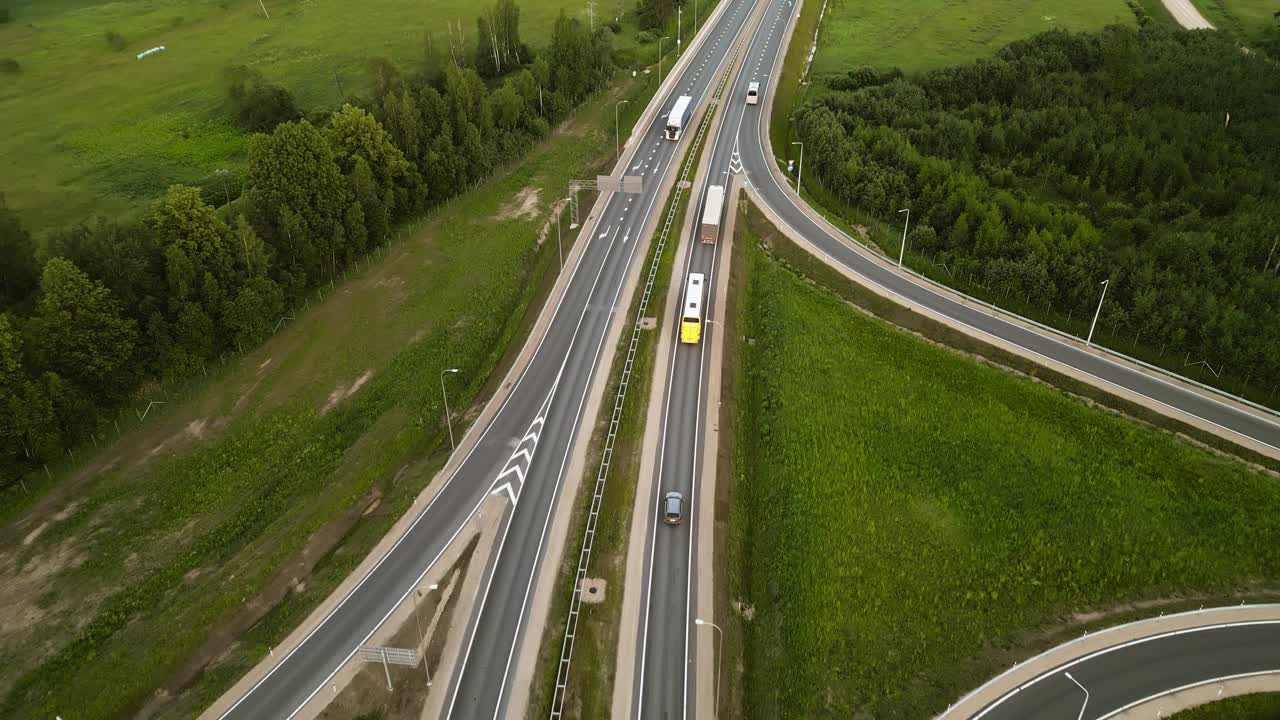 鸟瞰图，在风景如画的乡村风景中，一个高速公路交叉口被郁郁葱葱的绿色田野所包围视频素材