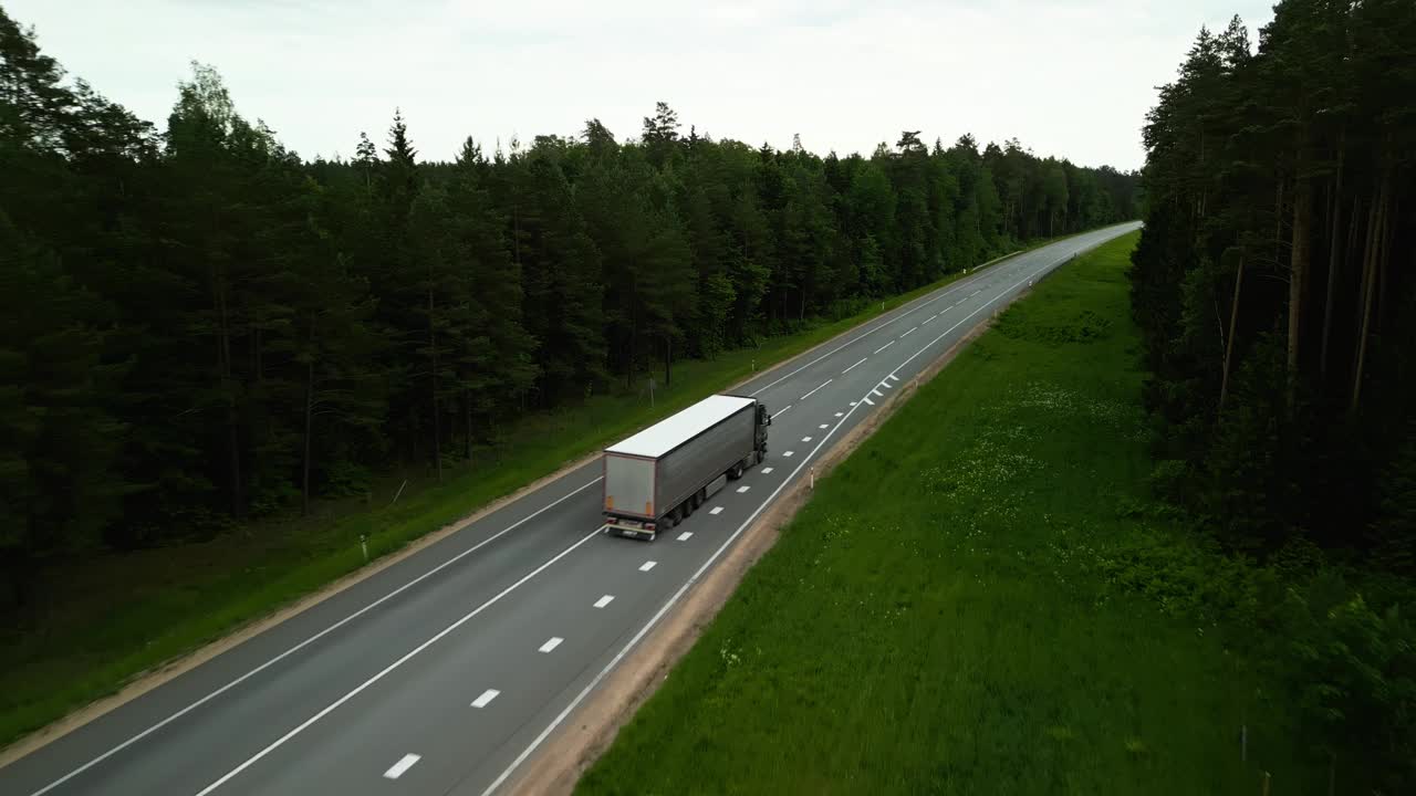 看一辆卡车在森林道路上的航拍画面，展示了美丽的风景和自然交通视频素材