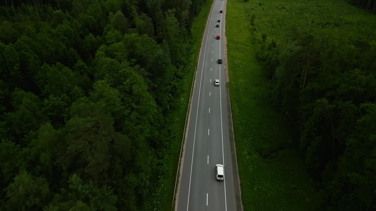 白天从空中观看森林道路上的车辆，行驶在风景优美的大自然中，绿树成荫视频素材