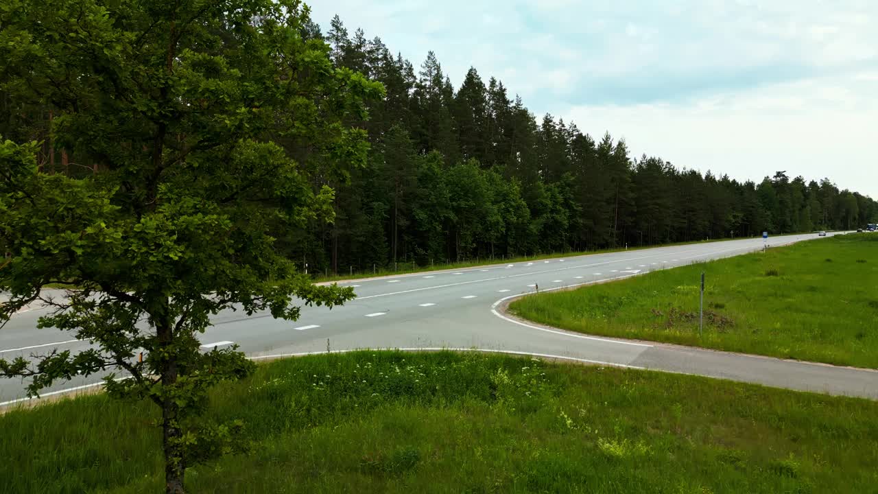 享受一个令人惊叹的鸟瞰图的汽车在森林道路上，显示了郁郁葱葱的绿色和周围的实时环境视频素材