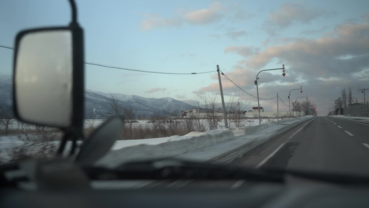 日本北海道岩井的雪道，山景和晴朗的天空，从一辆汽车上拍摄视频素材